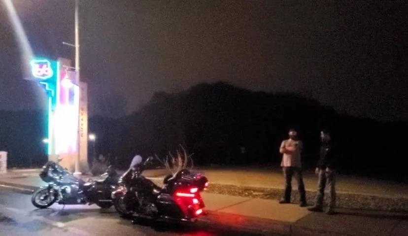 Motorcycles gathered in a parking lot at night
